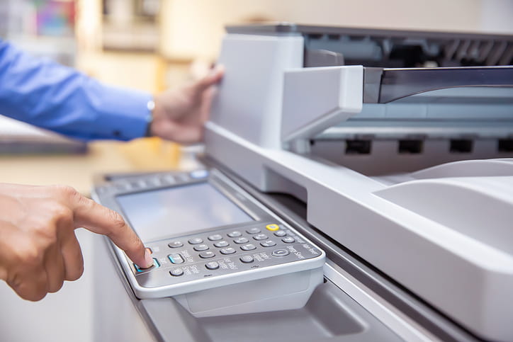 Hand operating a copier machine illustrating common copier problems in Palm Coast, FL
