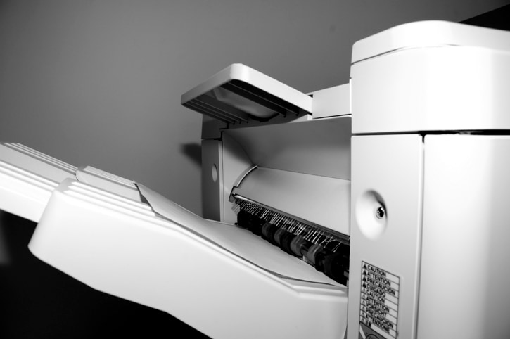 Close-up of a high-volume printer output tray and paper feed in New Smyrna Beach, FL
